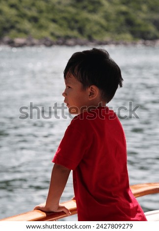 Exterior photo view portrait visual of a young eurasian asian handsome cute good looking kid chld children male boy who is happy during outdoor activities on summer time sunny weather