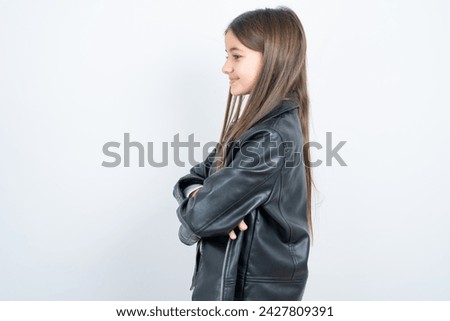 Portrait of Young beautiful teen girl wearing biker jacket standing with folded arms and smiling