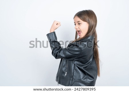 Profile side view portrait Young beautiful teen girl wearing biker jacket celebrates victory