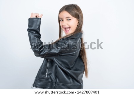 Portrait of funny Young beautiful teen girl wearing biker jacket shout yeah raise fists hands celebrate victory game competition