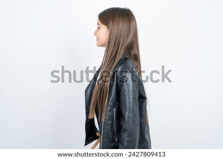 Profile portrait of nice Young beautiful teen girl wearing biker jacket look empty space toothy smile