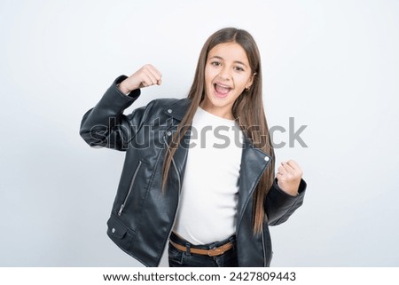 Hooray cool Young beautiful teen girl wearing biker jacket point back empty space hand fist