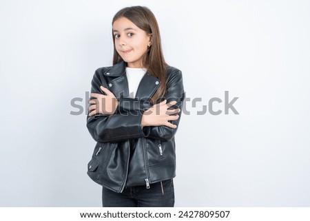 Young beautiful teen girl wearing biker jacket shaking and freezing for winter cold with sad and shock expression on face.