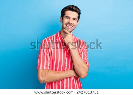 Photo of good mood clever man dressed striped shirt smiling arm chin isolated blue color background