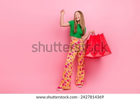 Photo of cheerful positive girl wear trendy clothes celebrate nice seasonal shopping empty space isolated on pink color background