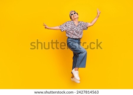 Full body photo of attractive pensioner woman dancing summer vibe dressed stylish leopard print clothes isolated on yellow color background
