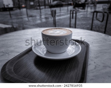 Close up of a light brown fresh mocha with beautiful latte art outdoors on a cafe in Paris