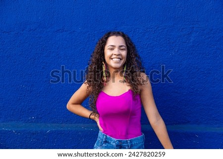 Beautiful young woman dressed for street carnival on blue background with free space for text