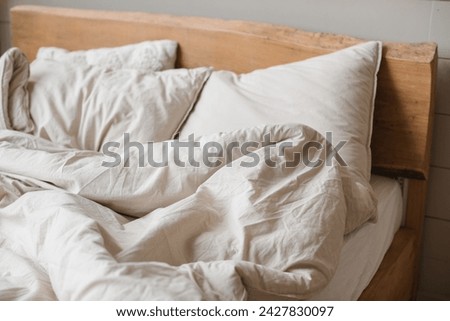 A bed with crumpled, stylish bed linen. Royalty-Free Stock Photo #2427830097