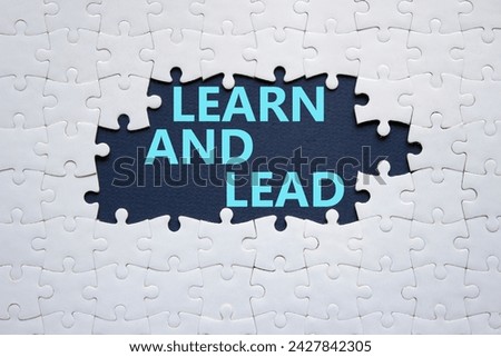 Learn and lead symbol. Concept words Learn and lead on white puzzle. Beautiful deep blue background. Business and Learn and lead concept. Copy space.