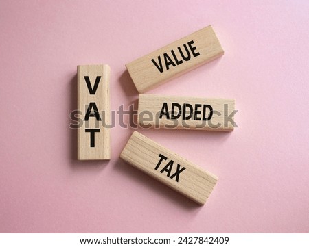 VAT - Value Added Tax symbol. Wooden cubes with word VAT. Beautiful pink background. Business and Value Added Tax concept. Copy space.