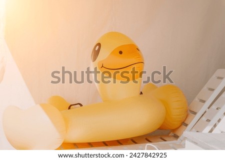 Inflatable duckling, summer - Bright yellow floatation device enhances swimming experience and safety ensured for young swimmers on warm summer days.