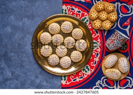 Top view of traditional arabic Eid-al-Adha, Eid -al-fFtr semolina maamoul cookies filled with dates, walnuts, and pistachios.                                Royalty-Free Stock Photo #2427847605