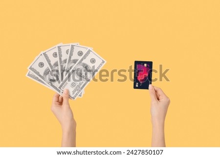 Woman with credit card and dollar banknotes on yellow background