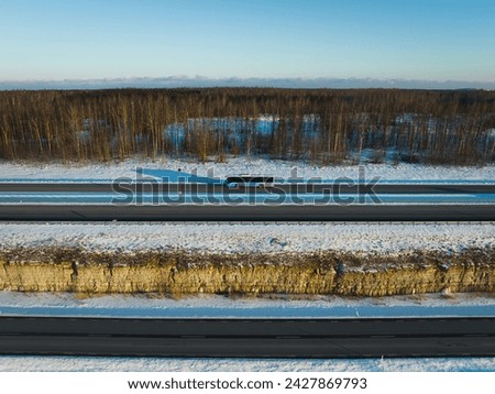 Aerial photo from a drone, a bus driving along a highway outside the city in winter. High quality photo
