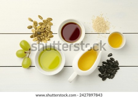 Vegetable fats. Different cooking oils and ingredients on white wooden table, flat lay
