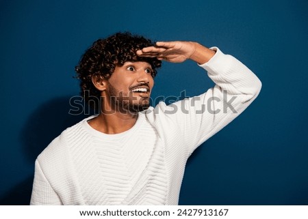 Photo of young man curly hair indian model touch forehead searching looking far away distance isolated on dark blue color background
