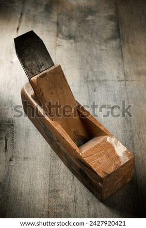 Close up of an old disused carpenter's plane on a work bench. Royalty-Free Stock Photo #2427920421