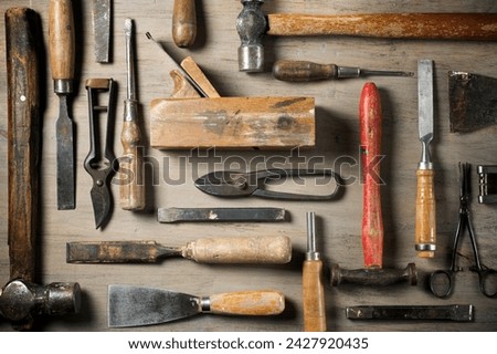 Close up of a group of disused hand tools on a work bench. Royalty-Free Stock Photo #2427920435