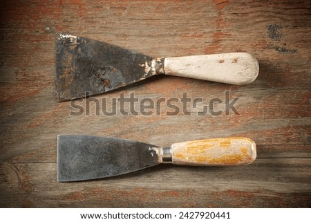 Close up of two old disused trowels on a work bench Royalty-Free Stock Photo #2427920441