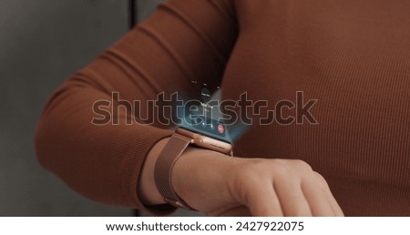 Woman fingers does double tap on smart watch for hands-free interaction. 3d rendering incoming call on smart watch. Young woman is typing on laptop at the work table at the office.