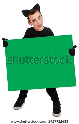 Emotional boy dressed as a black cat with green poster. White background. Purim, Halloween