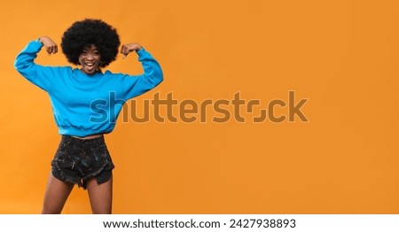 Happy African American woman in blue sweatshirt.