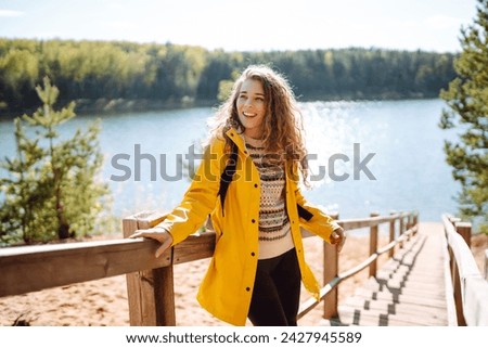 Woman traveler on a wooden ladder. Young woman enjoying nature on a sunny day. Active lifestyle. Travel concept.