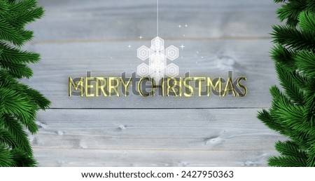 Image of merry christmas text over snowflake and fir tree branches on wooden background. Christmas, tradition and celebration concept digitally generated image.