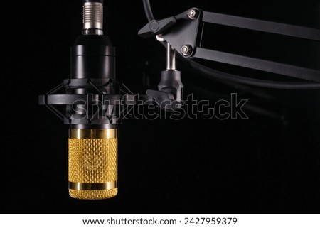 Studio microphone for podcast and voice recording on a black background with space for inscription