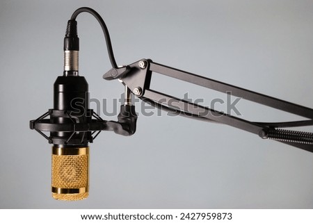 Studio microphone for podcast and voice recording on a gray background with space for inscription
