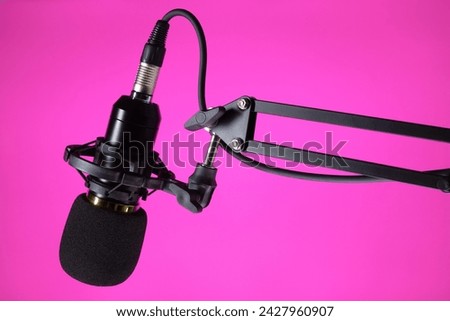 Studio microphone for podcast and voice recording on a purple background with space for inscription