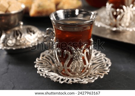 Traditional Turkish tea served in vintage tea set on black table, closeup