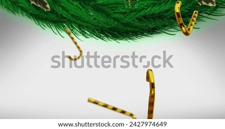 Image of candy canes christmas decorations over fir tree branches on white background. Christmas, tradition and celebration concept digitally generated image.