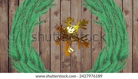 Image of gold snowflake christmas decoration and green branches on wooden background. Christmas, tradition and celebration concept digitally generated image.