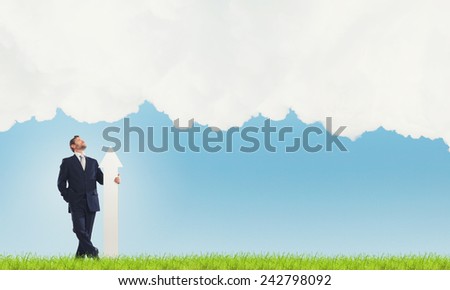 Businessman in suit with white blank arrow in hands