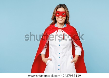 Female smiling happy cheerful doctor man wears white medical gown suit red super hero coat mask work in hospital looking camera isolated on plain blue background studio. Healthcare medicine concept