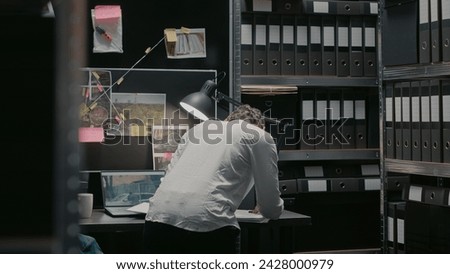Law agent analyzing forensic evidence of criminal case, doing research to solve crime. Female inspector searching for clues and analyzing surveillance photos on board, felony charges. Royalty-Free Stock Photo #2428000979