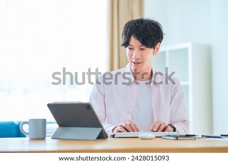 Young man operating a computer in his room