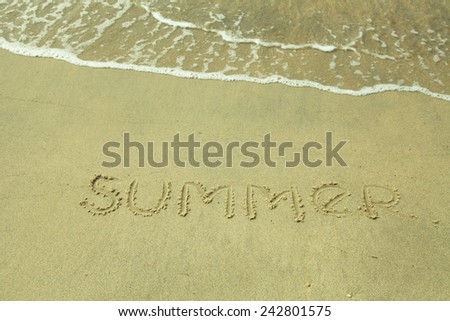 The Word Summer written on the sand  beach and sea waves.Toned image