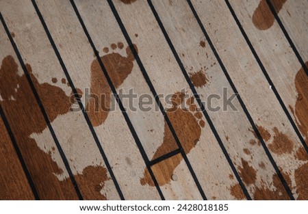 Exterior photo visual view of wet foot prints on a wood floor ground during summer on a boat or wooden platform near the sea or ocean during hot heat summer time with nice holiday weather