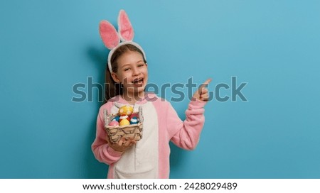 Cute little child wearing bunny ears on Easter day. Girl with painted eggs. Royalty-Free Stock Photo #2428029489