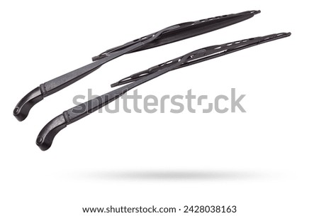 A pair of black plastic wipers on a white isolated background with rubber brushes for cleaning from dirt, dust or rain without hampering the driver's visibility. Spare part for the car at the parsing. Royalty-Free Stock Photo #2428038163