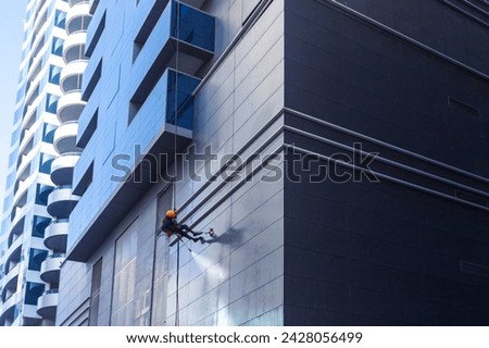 Professional worker cleaner cleaning building  facade. Professional cleaning sevice. Royalty-Free Stock Photo #2428056499