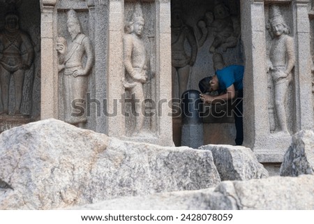A hindu person praying to Shivling at world famous UNESCO world heritage site of Mahabalipuram. Ajanta, Ellora, Hampi, Ancient, stone sculpture carvings, sacred pilgrimage, sanatan, love, architecture Royalty-Free Stock Photo #2428078059