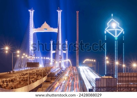 The Rama IX parallel bridge is adorned with colorful lights that create a stunning visual spectacle. It is considered to be Thailand's first double cable-stayed bridge across the Chao Phraya River. Royalty-Free Stock Photo #2428088029