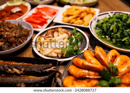 a table full of sumptuous food, including golden grilled squid, Royalty-Free Stock Photo #2428088727