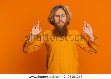 Keep calm down, relax, rest. Concentrated happy Caucasian man meditating breathes deeply with mudra yoga gesture, eyes closed, peaceful mind, taking a break. Redhead guy isolated on orange background