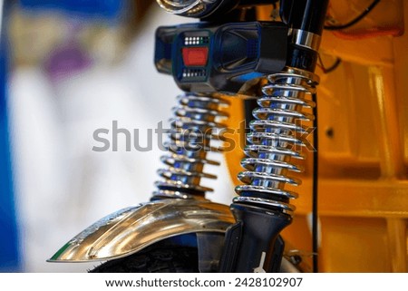 Close-up of shock absorber suspension spring on motorcycle front wheel
