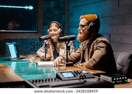 Two young stylish radio show hosts record fresh podcast episode in home loft studio apartment Royalty-Free Stock Photo #2428108459
